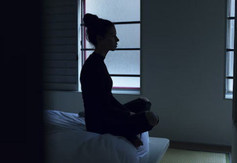 Женщина бессонно сидит в конце своей кровати. | © Pixabay