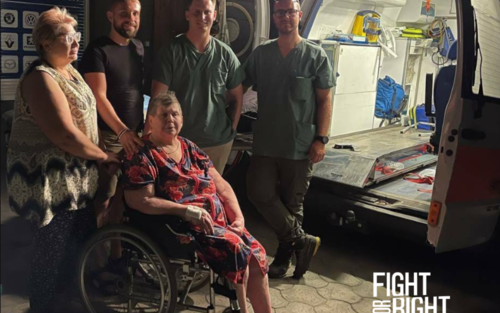 Медичні працівники допомагають жінці на інвалідному візку