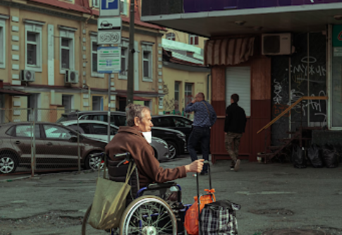 Человек на инвалидной коляске с вещами ищет убежище во время войны. | © Unsplash